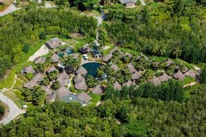 Luftaufnahme des Constance Ephelia Resorts mit tropischen Bungalows und Pools inmitten grüner Vegetation.