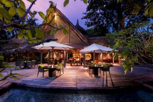 Terrasse des Constance Ephelia Resorts bei Nacht mit beleuchteten Tischen und Stühlen.