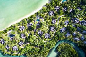 Aussenansicht des Constance Ephelia Resorts mit vielen kleinen Häusern, Pools und einem Fluss