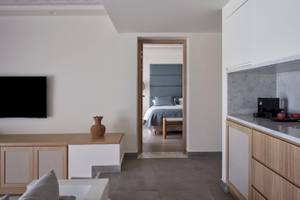 Innenansicht des Atlantica Beach Resort Kos mit modernem Wohnbereich und Schlafzimmer.