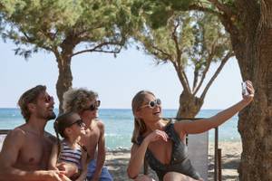 Familie, die Selfies am Strand vor dem Atlantica Beach Resort Kos macht.