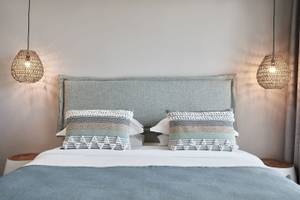 Schlafzimmer im Atlantica Beach Resort Kos mit einem Bett, Kissen, und dekorativen Lampen.