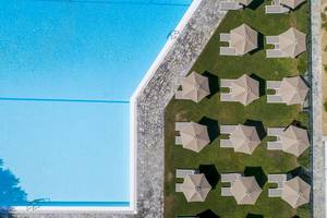 Hotelpool mit Liegestühlen und Sonnenschirmen aus der Luft