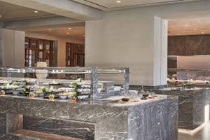 Speisebereich des Atlantica Beach Resort Kos mit Marmortheke und verschiedenen Speisen.