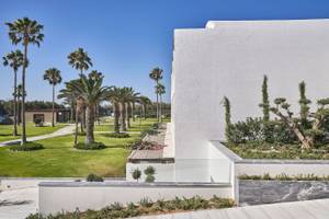 Außenbereich des Atlantica Beach Resort Kos mit weißen Gebäuden und Palmen