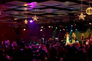 Veranstaltung im Nirvana Cosmopolitan Hotel mit Band, Lichterketten und Publikum.