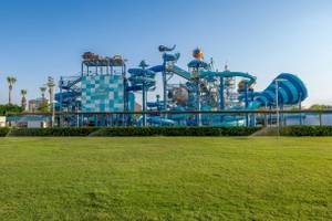 Wasserpark Aqua Atlantis mit großen blauen Rutschen und grüner Rasenfläche