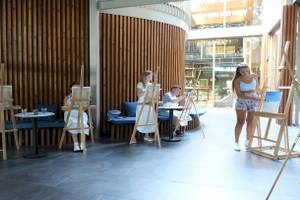 Gäste im Nirvana Cosmopolitan Hotel malen an Staffeleien