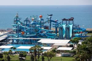 Luftaufnahme des Nirvana Cosmopolitan Wasserparks am Meer mit mehreren Wasserrutschen und einem großen Pool.