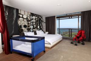 Nirvana Cosmopolitan Hotel Zimmer mit Bett und Kinderwagen am Meer