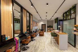 Innenansicht des Nirvana Cosmopolitan Hotels mit Friseursalon, Spiegeln, Stühlen und Empfangstresen.