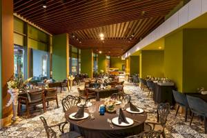 Innenraum des Nirvana Cosmopolitan Hotels mit vielen gedeckten Tischen und Stühlen.