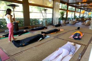 Gruppe von Menschen, die im Nirvana Cosmopolitan Hotel Yoga üben, mit einer Lehrerin in der Mitte.