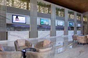 Lobby-Sitzbereich des Nirvana Cosmopolitan Hotels mit Marmorboden und Monitoren.