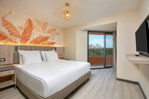 Megasaray Resort Side Hotelzimmer mit Terrasse und Ausblick auf Bäume.