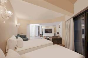 Doppelzimmer im Megasaray Resort Side mit zwei Betten, Fernseher und Sofa.