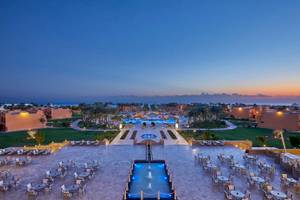 Luftaufnahme des Jaz Grand Marsa Hotels mit Swimmingpools und Außenbereichen bei Sonnenuntergang.