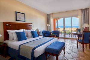 Jaz Grand Marsa Hotel Zimmer mit Meerblick, komfortablem Bett und Sitzbereich.