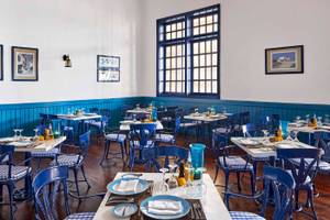 Innenansicht des Restaurants im Jaz Grand Marsa Hotel mit blauen Stühlen und Tischen.