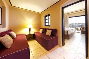 Innenansicht einer Suite im Jaz Lamaya Resort mit zwei Sofas, Tisch und Lampe.