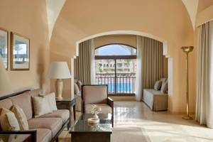 Wohnzimmer des Jaz Lamaya Resorts mit Sofa, Tisch, Lampe und Terrassenfenster mit Poolblick