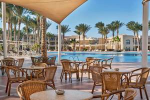 Außenterrasse mit Tischen und Stühlen am Pool im Jaz Lamaya Resort