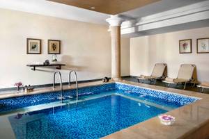 Ein Schwimmbad im Jaz Lamaya Resort mit blauen Fliesen und Liegestühlen.