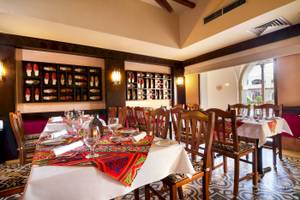 Innenansicht des Restaurants im Jaz Lamaya Resort mit gedeckten Tischen und Stühlen.