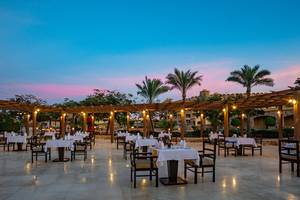 Foto von einem Außenbereich des Utopia Beach Club Hotels mit runden Tischen und Stühlen.