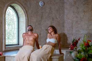 Ein Paar genießt die Sauna im Utopia Beach Club Hotel, mit Blumen im Vordergrund.