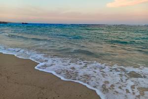 Foto vom Utopia Beach Club zeigt das Meer am Abend mit sanften Wellen am Strand.