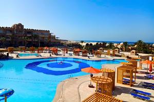 Aussicht auf den Poolbereich des Utopia Beach Club Hotels mit mehreren Schwimmbecken und Sonnenschirmen.