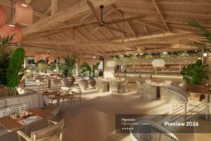 Vorschau 2026 des Innenbereichs des Hipotels Hipocampo Palace mit Holzdecken, Rattanmöbeln und Pflanzen.