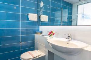 Blaue Fliesen Badezimmer mit Toilette und Waschbecken in einem anonymen Hotel