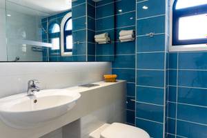 Badezimmer mit blauen Fliesen und einem weißen Waschbecken