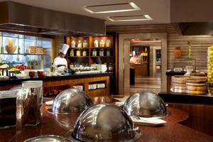 Restaurantbuffet im Jumeirah Beach Hotel mit einem Koch, der Gerichte vorbereitet.