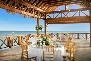 Foto von der Terrasse des Sunscape Dominicus La Romana mit Blick auf das Meer und gedeckten Tischen.