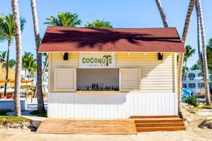 Coconuts Beach Bar im Sunscape Dominicus La Romana mit vielen Flaschen und tropischen Palmen im Hintergrund
