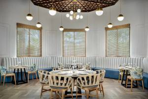 Interieurbereich eines Restaurants mit Tisch, Stühlen und gepolsterten Bänken.