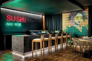 Innenansicht des Sushi und Wok Restaurants im Sunscape Dominicus La Romana mit einer neonroten Beleuchtung und einer Wandmalerei.