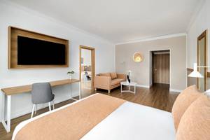 Hotelzimmer im Sunscape Dominicus La Romana mit Fernseher, Schreibtisch, Bett und Sofa.