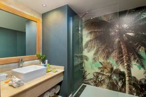 Badezimmer im Sunscape Dominicus La Romana Hotel mit Palmentapete und blauen Wänden.