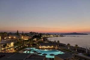 Abendlicher Blick auf das Atlantica Kalliston Resort mit Pool, Bars und Strand.