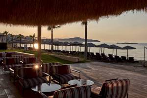 Aussicht auf die Terrasse des Atlantica Kalliston Resorts mit Sonnenuntergang am Meer.