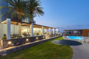 Terrasse des Astir Beach Hotels auf Kreta bei Abendbeleuchtung mit Palmen und Pool.