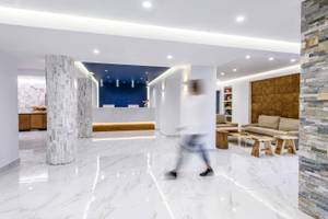 Lobby des Arminda Hotel & Spa mit weißen Marmorboden und modernen Möbeln.