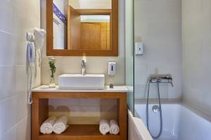 Badezimmer im Arminda Hotel & Spa mit Badewanne, Waschbecken und Handtüchern