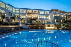 Arminda Hotel & Spa bei Nacht mit beleuchtetem Außenpool und Loungestühlen.