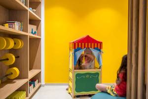 Im Arminda Hotel, Kinderzimmer mit einem Spielzelt und einem Bücherregal.