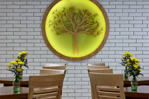 Arminda Hotel & Spa Innenraum mit Baum Wandkunst und Tischen mit Blumenvasen.